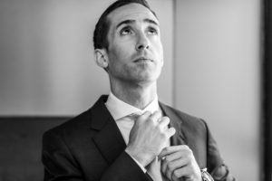 Anthony fixes his tie to prepare for his Sunday wedding